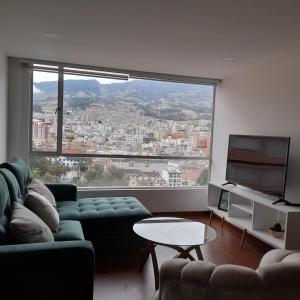 - un salon avec un canapé et une grande fenêtre dans l'établissement Apartamento panorámico de lujo en el Centro de Pasto, à Pasto