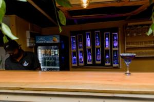 a man standing behind a bar with a drink at New Bay View Villa in Weligama