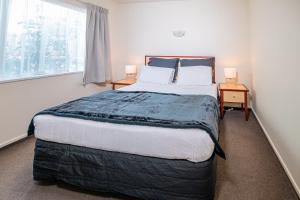- une chambre avec un grand lit et une fenêtre dans l'établissement Daffodil Motel, à Christchurch