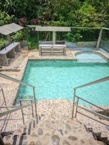 una gran piscina con un banco y una mesa en Comodo Alojamiento en San cipriano, en San Cipriano