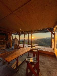a wooden table in a room with a view of the sunset at Rinjani Houseboon in Senaru
