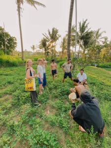 a group of people standing in the grass with a sign at Rinjani Houseboon in Senaru