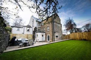 a house with a green lawn in front of it at Foxlow Grange By Muse Escapes in Buxton