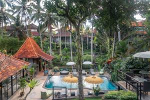 uma vista para a piscina num resort com guarda-sóis em Narasoma Homestay & Retreat em Ubud