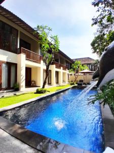 a swimming pool in front of a house at Sekuta Condo Suites in Sanur