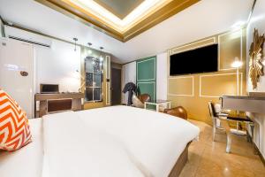 a bedroom with a large white bed and a television at Gongju No 25 Hotel in Gongju
