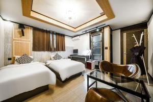 um quarto de hotel com duas camas e uma secretária em Gongju No 25 Hotel em Gongju
