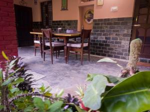 a patio with a wooden table and chairs at Raadballi Retreat in Kangra