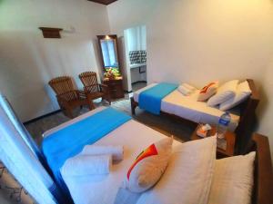 a bedroom with two beds and a living room at Dinu Lanka Resort in Katunayaka