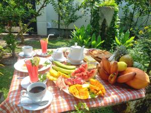 a picnic table with a plate of fruit and a cup of coffee at Dinu Lanka Resort in Katunayaka
