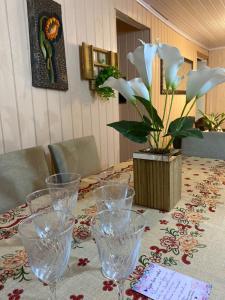 einen Tisch mit Brille und eine Vase mit Blumen darauf in der Unterkunft Casa a 500m do Natal Luz de Gramado in Gramado