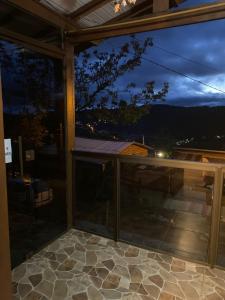 Blick aus einem Glasfenster auf eine Terrasse in der Unterkunft Casa a 500m do Natal Luz de Gramado in Gramado