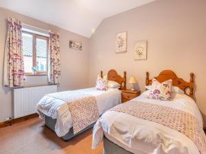 a bedroom with two beds and a window at Ash Cottage - Uk45581 in Maltby le Marsh
