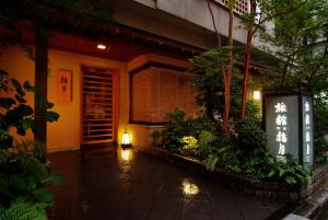 東京的住宿－淺草指月日式旅館，灯笼和植物的建筑物入口