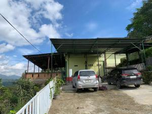 dos coches estacionados frente a un edificio en RedDoorz near Pelabuhan Ajibata Parapat, en Parapat