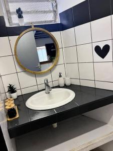 a bathroom with a sink and a mirror at Bungalow le goyavier in Goyave