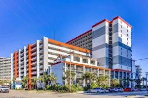 un gran edificio con coches estacionados en un estacionamiento en Breathtaking Oceanfront 3BR,2BA Suite/Grand Cayman 451, en Myrtle Beach