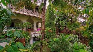 ein Gebäude mit einem Balkon inmitten eines Gartens in der Unterkunft Hidden Paradise - Budi Susanto in Kalasan