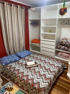 ein Schlafzimmer mit einem Bett und einem Schrank in der Unterkunft Casa a 500m do Natal Luz de Gramado in Gramado