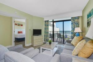 sala de estar con sofá, TV y cama en Breathtaking Oceanfront 3BR,2BA Suite/Grand Cayman 451 en Myrtle Beach