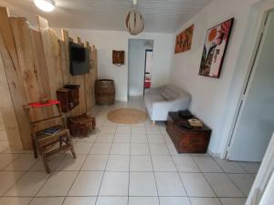 ein Wohnzimmer mit einem Sofa und einem TV in der Unterkunft Villa Korail Caraibes in Les Trois-Îlets
