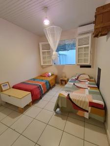 a bedroom with two beds and a window at Villa Korail Caraibes in Les Trois-Îlets