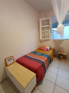 a small bedroom with a bed and a window at Villa Korail Caraibes in Les Trois-Îlets