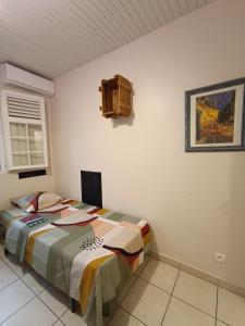 a bedroom with a bed and a painting on the wall at Villa Korail Caraibes in Les Trois-Îlets