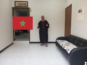 a man standing in a room with a syrian flag at Nursery Inn in Karachi