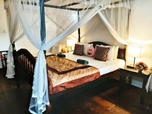 a bedroom with a large bed with a canopy at Villa Blue Ocean in Mirissa