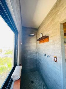 a small bathroom with a shower with a window at Casa Vista Hermosa in San Juanico