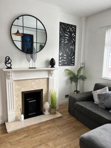 a living room with a fireplace and a mirror at Glendale Gardens Apartment in Southend-on-Sea