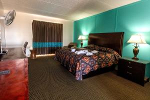 a hotel room with a bed and a dresser and a bedroom at CRYSTAL PALACE RESORT in Bolivar Peninsula