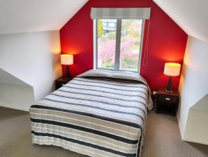 niewielka sypialnia z łóżkiem i oknem w obiekcie Hanmer Apartments w mieście Hanmer Springs