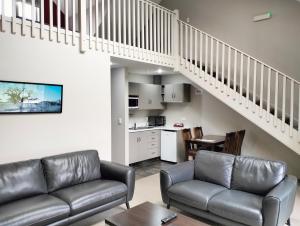 a living room with a couch and a staircase at Hanmer Apartments in Hanmer Springs