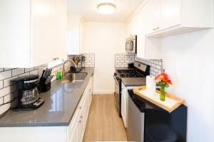 a kitchen with white cabinets and black counter tops at Cozy Koreatown/Hollywood 2 Bedroom in Los Angeles