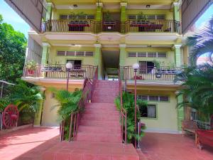 eine Treppe, die zu einem Gebäude mit einem Balkon führt in der Unterkunft Phalla Riverside in Kampong Cham