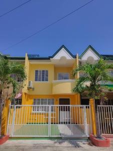 a yellow house with palm trees in front of it at Private Guest House Bay Breeze in San Juan