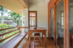 a wooden table on the balcony of a house at Betel Palm Village - Casa Retreat - WiFi 90 Mbps in Pai
