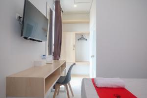 Alastuwo的住宿－RedDoorz Syariah @ Tlogosari Semarang，客房设有书桌、电视和床。