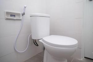 Alastuwo的住宿－RedDoorz Syariah @ Tlogosari Semarang，浴室设有白色卫生间和软管