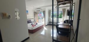 a bedroom with a bed and a room with a chair at At Home Hotel in Patong Beach