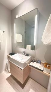 y baño con lavabo blanco y espejo. en Diamond Phuket Bang Tao en Bang Tao Beach