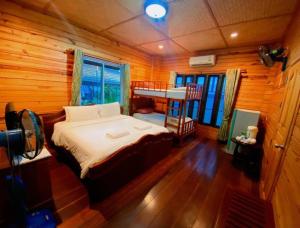 a bedroom with a bed in a wooden cabin at Baan Soontree Resort in Chiang Rai