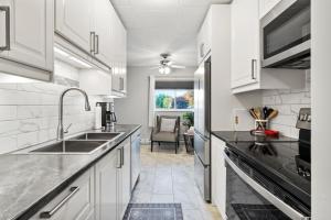a kitchen with white cabinets and a sink at Elm Park in Port Colborne