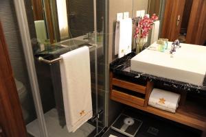 Pacific Business Hotel في تايبيه: حمام مع حوض ودش زجاجي