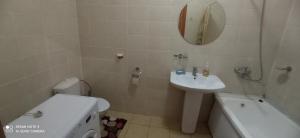 a bathroom with a sink and a toilet and a mirror at Валиханова Абая in Astana