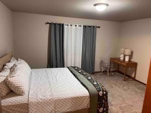 a bedroom with a bed and a desk and a window at 5 STAR Rating Home on Rock Island Golf Course 