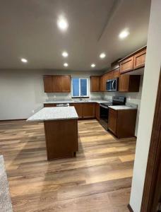 a large kitchen with wooden floors and wooden cabinets at 5 STAR Rating Home on Rock Island Golf Course 