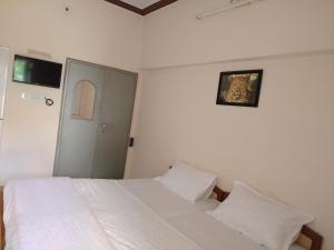 a bedroom with a white bed with two pillows at Red king home stay in Bikaner